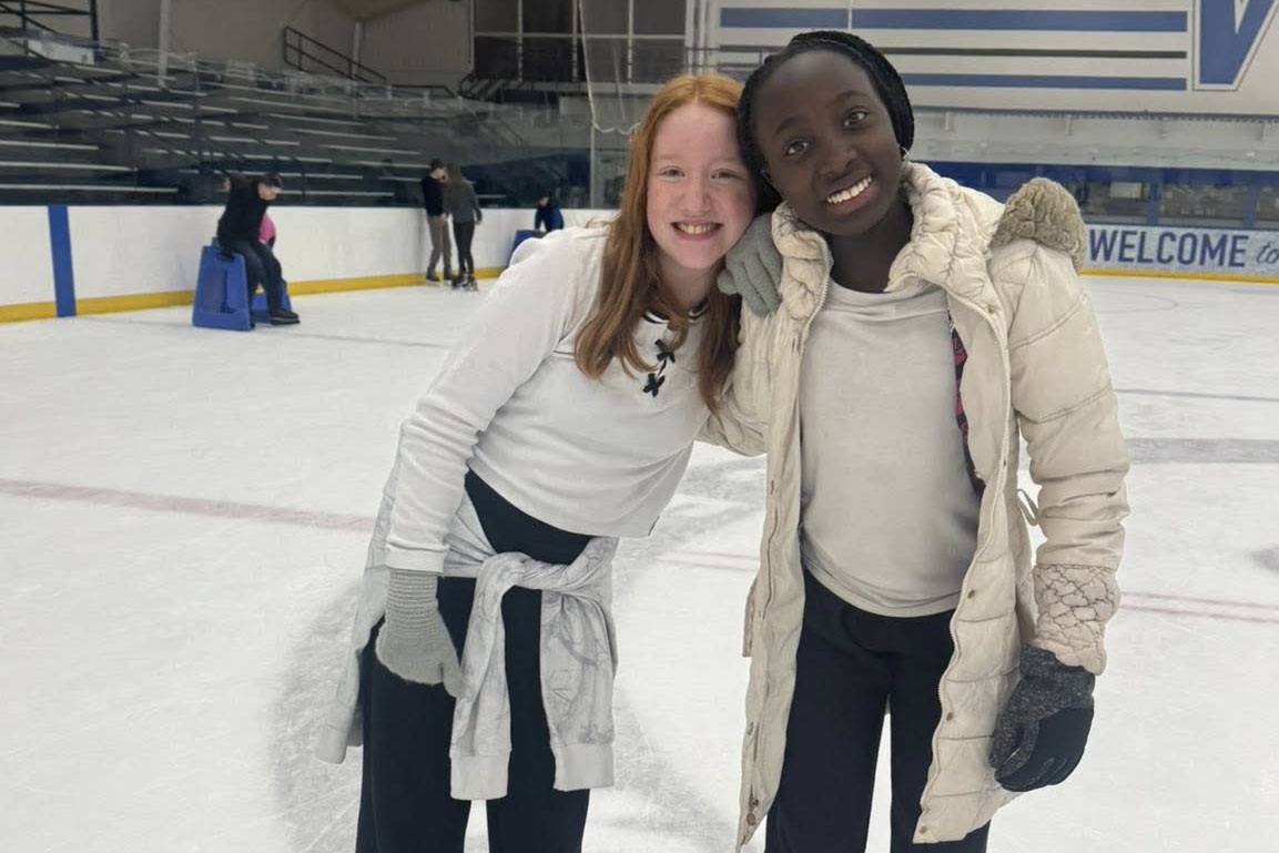 Two students posing together at ice rink