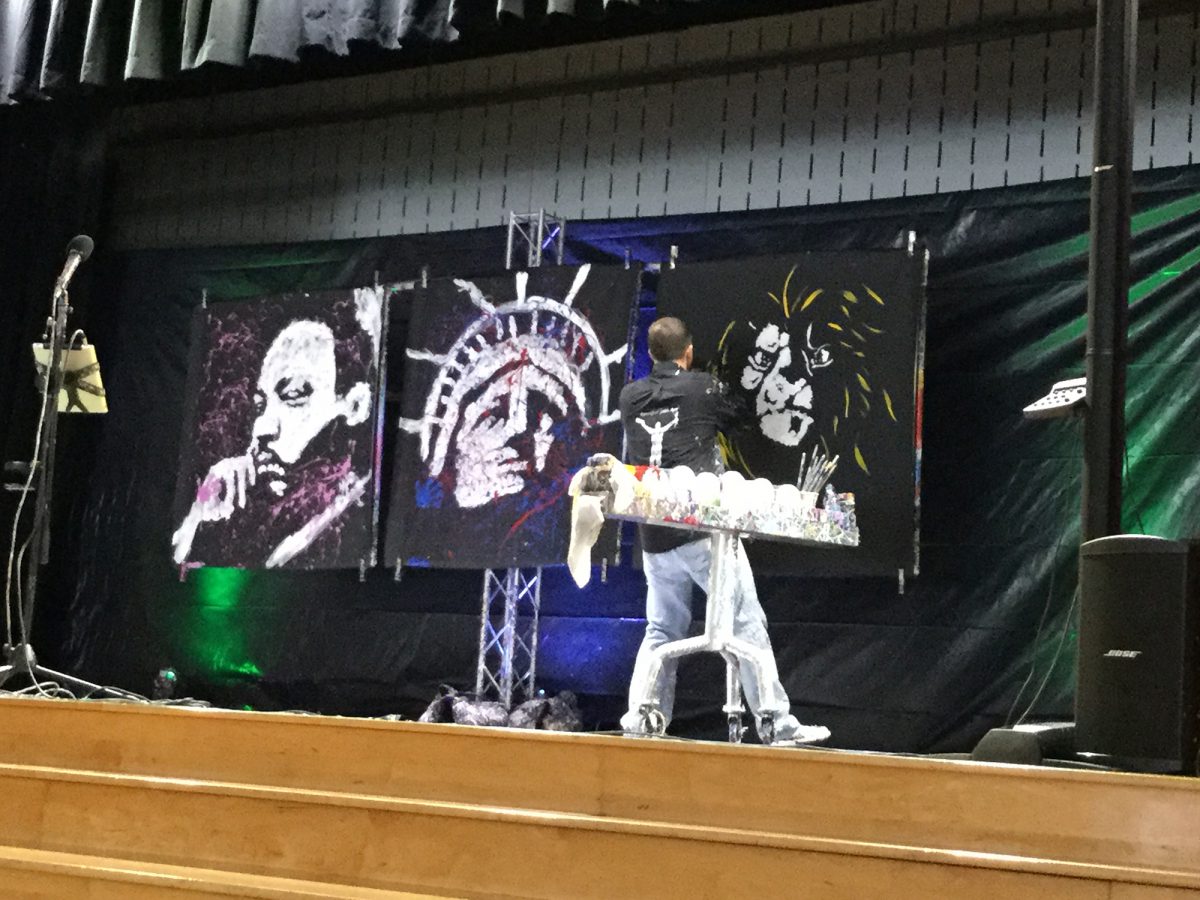Painter stands on stage with his back to the audience