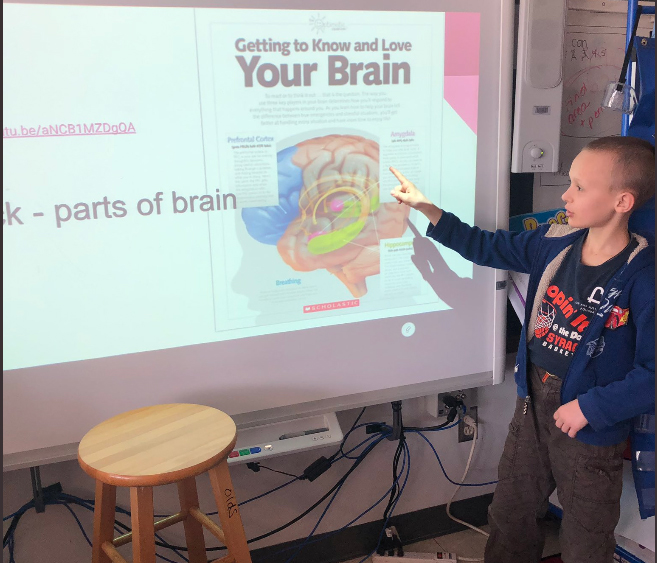 Student points to slide that reads "Getting to know and love your brain"