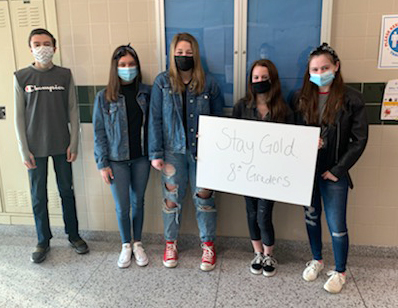 Five students hold up a sign that says Stay Golden