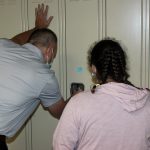 A teacher helps a student with a locker combination