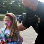 A student stands with a police officer