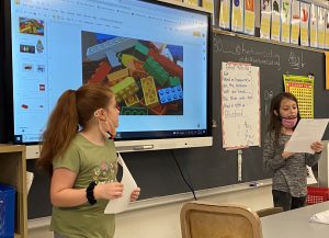 Two fourth grade students present a project in front of the class