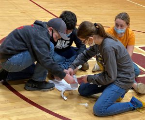 Four students work on a project in the gym 