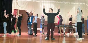 students rehearse for a musical on stage