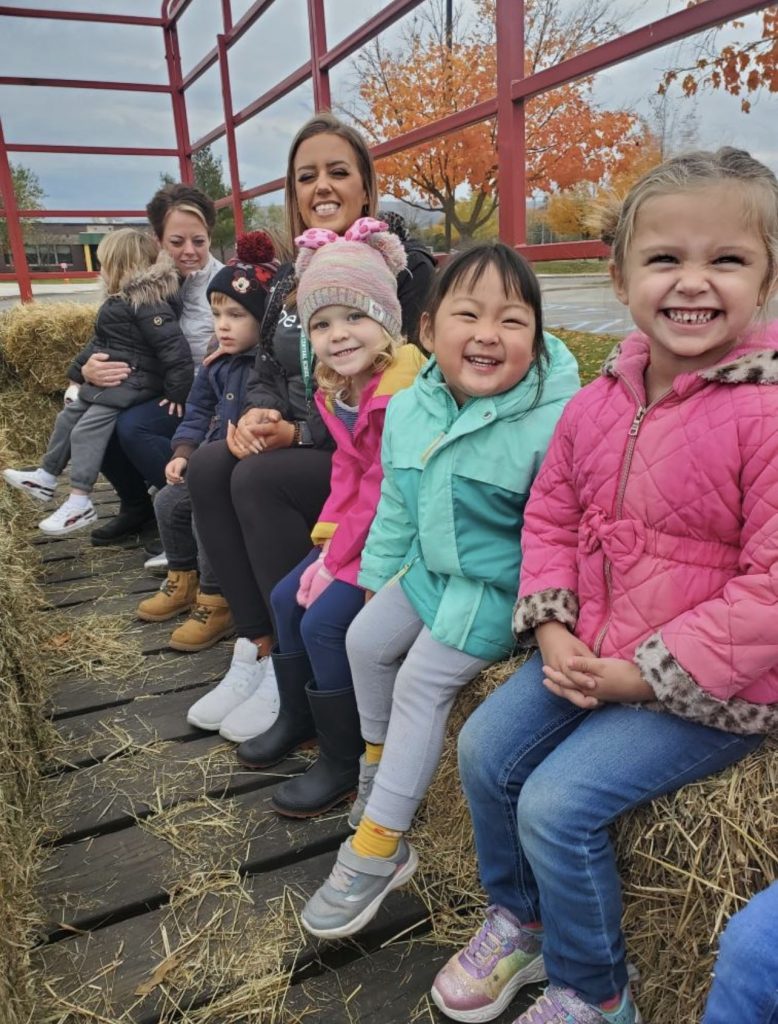PreK students sitting on hay bales at Annutto's