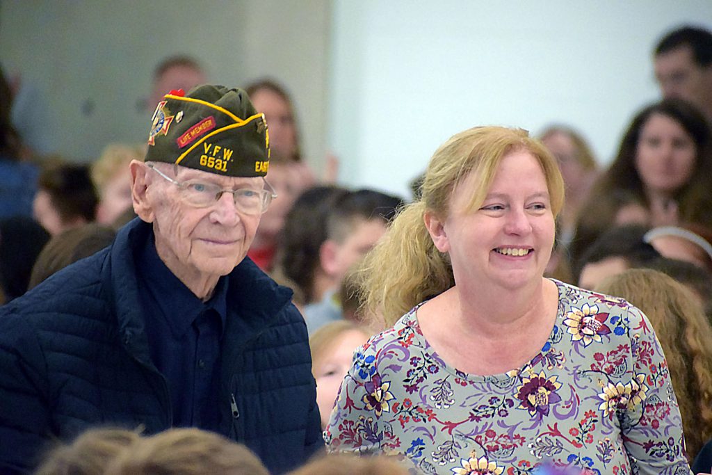 Veteran and his daughter walking to the front of the assembly