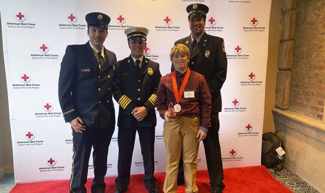 Brett Saunders and firefighters as Brett poses with Youth Good Samaritan Award