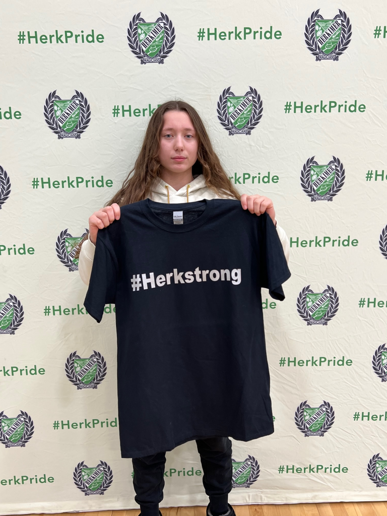 Student Jovanna Pugliese holding up a #HerkStrong shirt received for winning a PE character recognition award