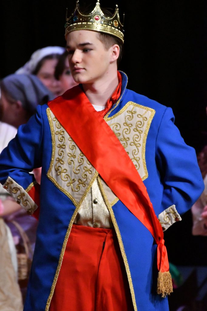 Student playing Prince Topher on stage