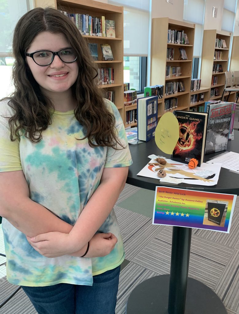 Student posing with her Book Bento in the library