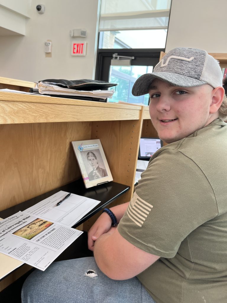 Seventh grade officer with a printed newspaper from a project about the magic of women's history