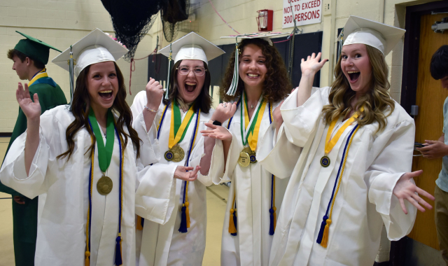 Four students celebrating at graduation