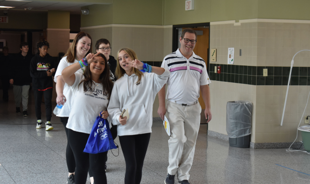 Students and teacher walking for mental health walk in hallway