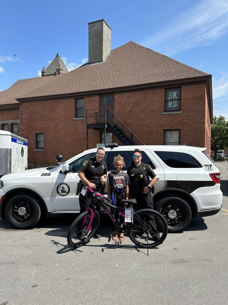 Two police officers with a child and a bike