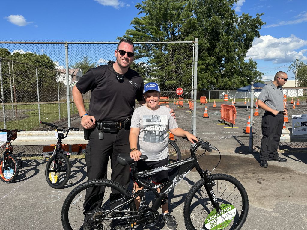 Police officer with a child and a bike