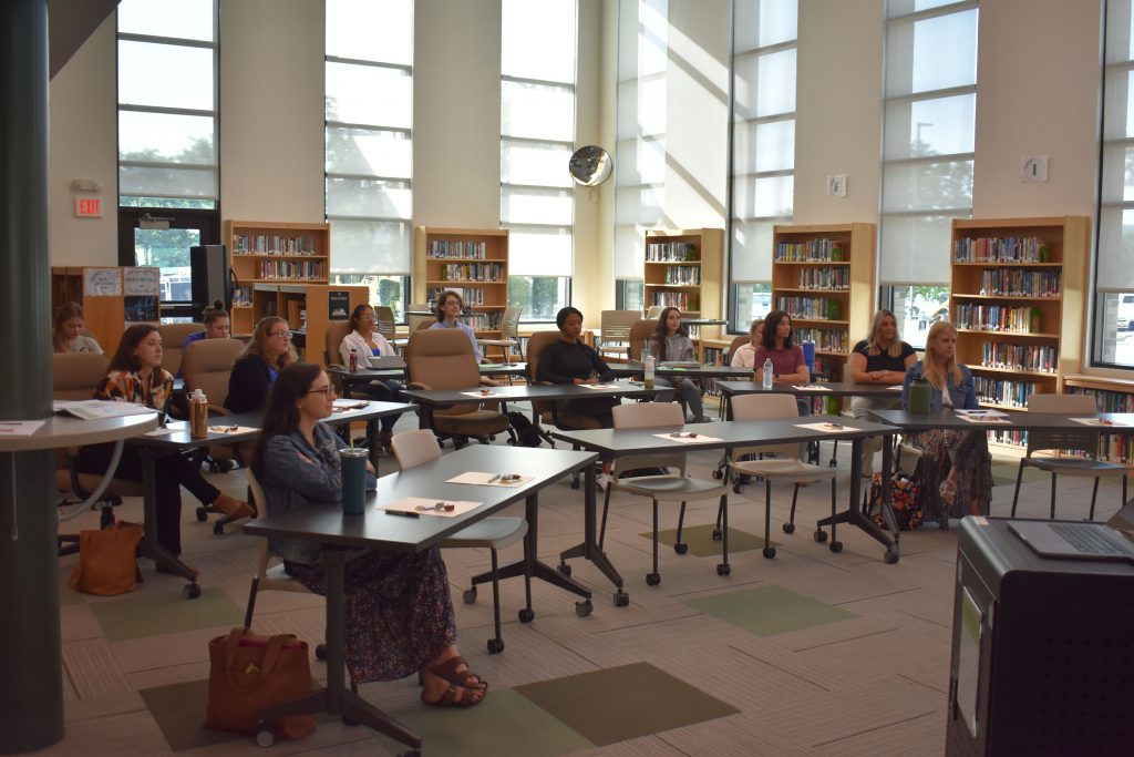 New teachers and staff at orientation in the library