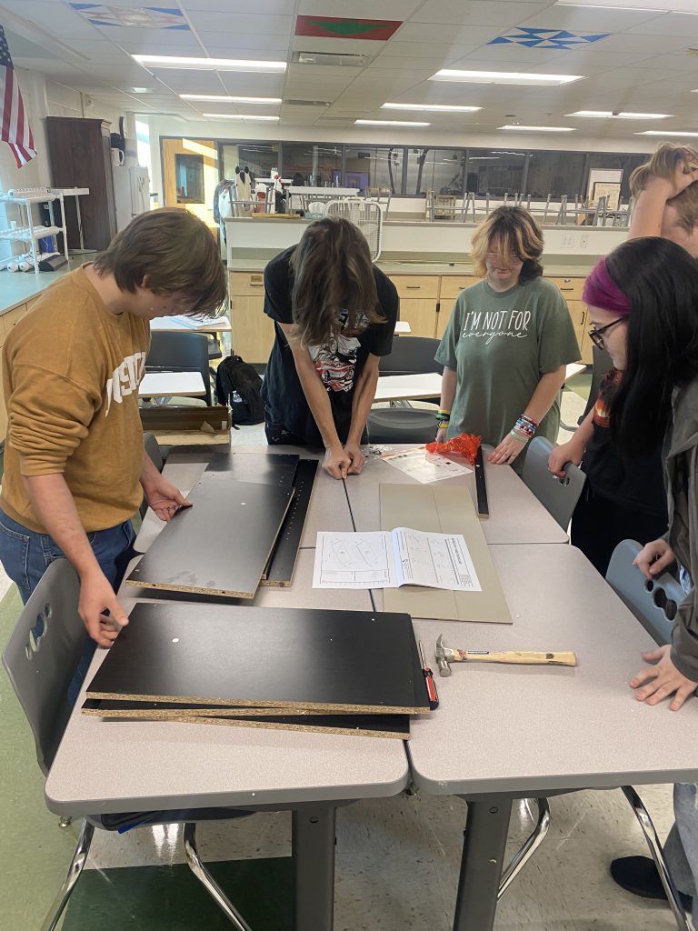 Students putting together bookshelves