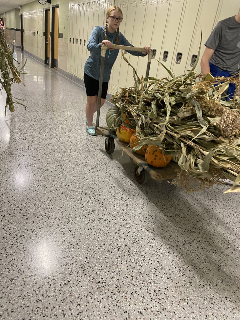 Student in high school hallway transporting materials for sign