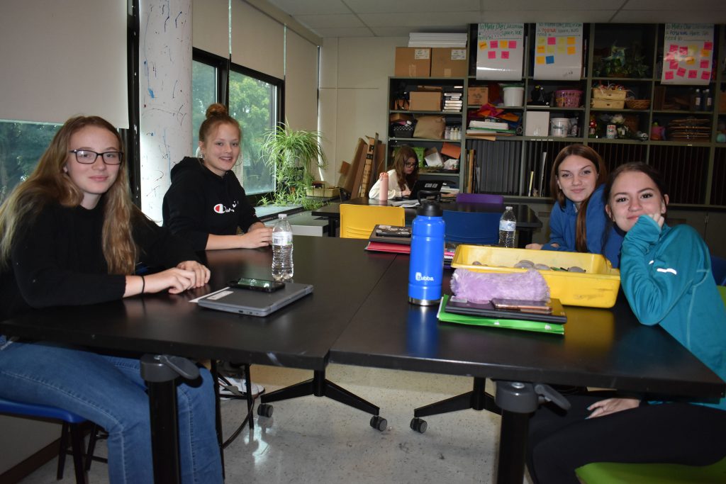 Social emotional artistic learning students in class working on their wood coins with inspirational messages