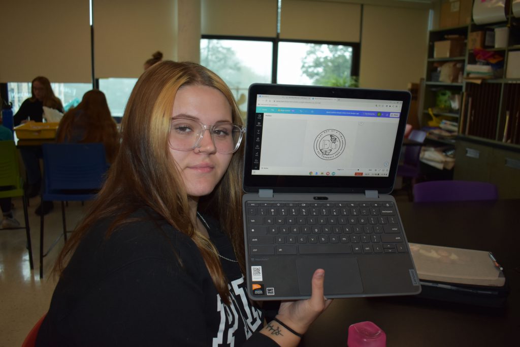 Social emotional artistic learning student next to her coin design on a computer screen