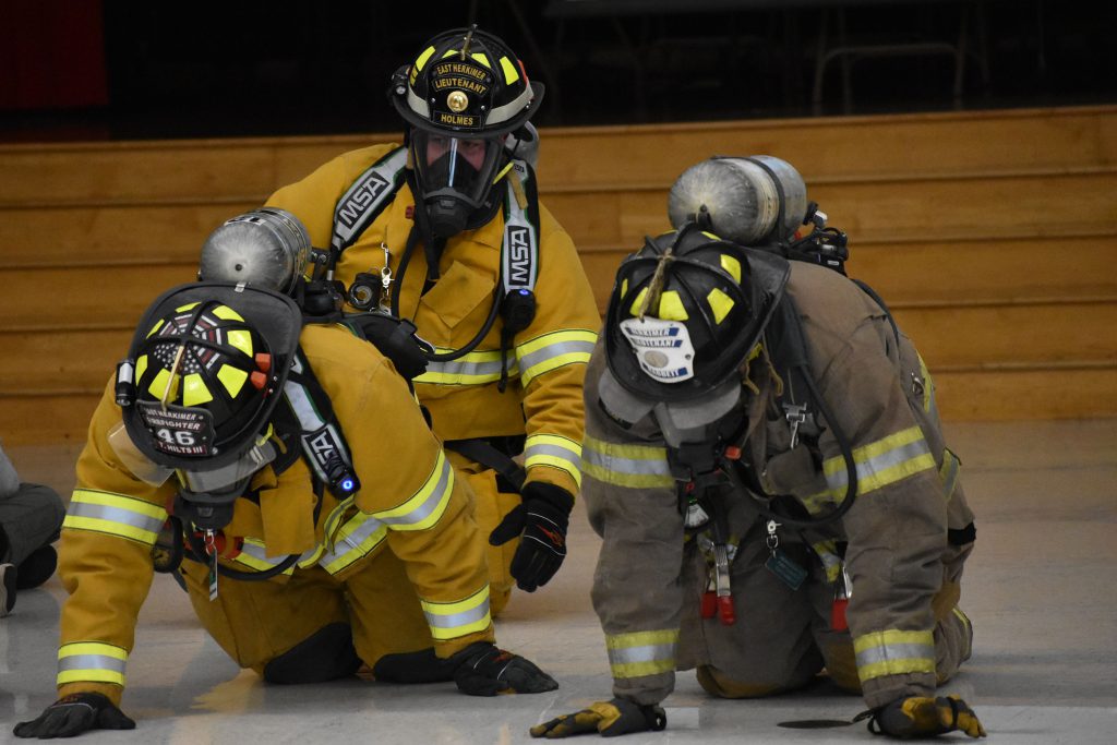 Firefighters crawling in full gear at Fire Safety Assembly