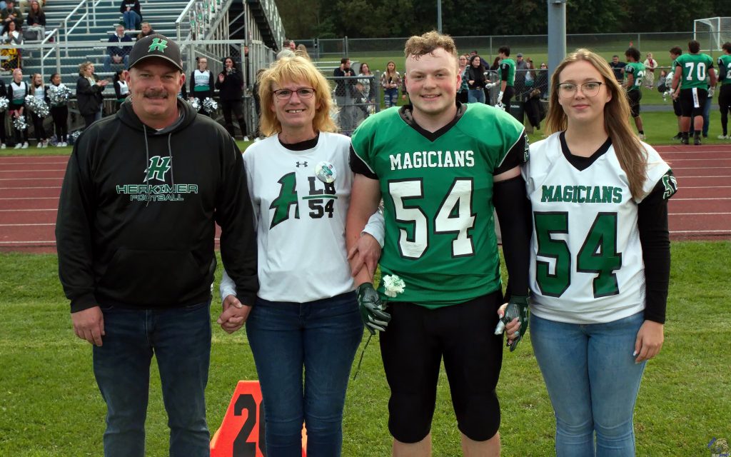 Herkimer senior Michael Goodson with his parents and girlfriend on the football field.