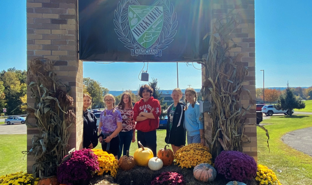 Ag landscape students by high school entrance sign