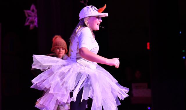 Student in a snowgirl costume on stage