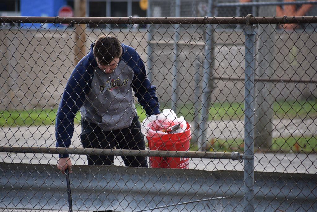 Student picking up litter at Harmon Park