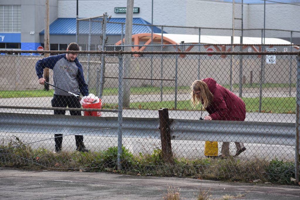 Student and teacher picking up litter at Harmon Park