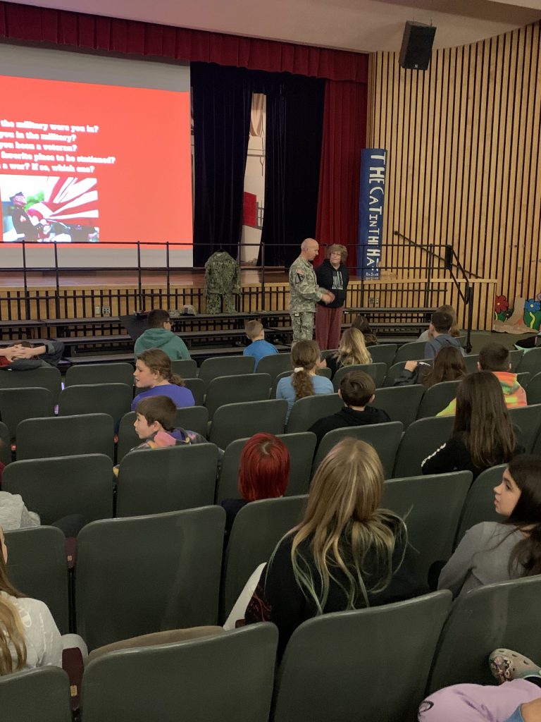 Herkimer teachers Nick Sheldon and Leah Peyton talking to sixth grade students at an assembly