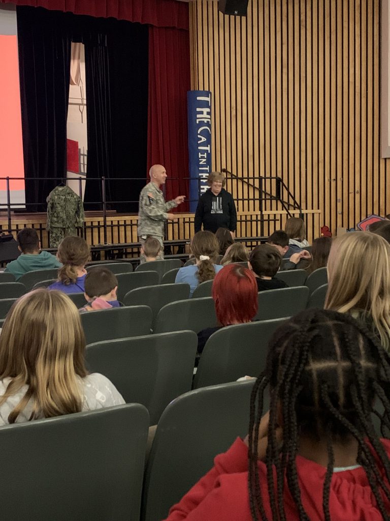 Herkimer teachers Nick Sheldon and Leah Peyton talking to sixth grade students at an assembly