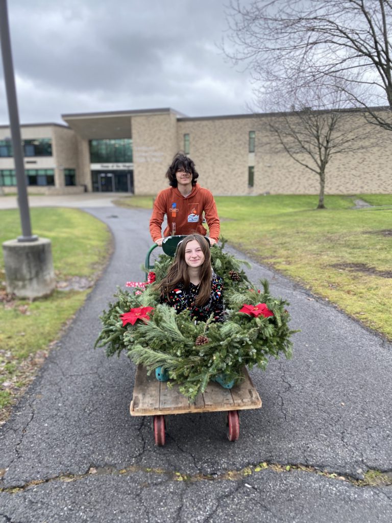 Landscape design students bringing festive display arrangements outside