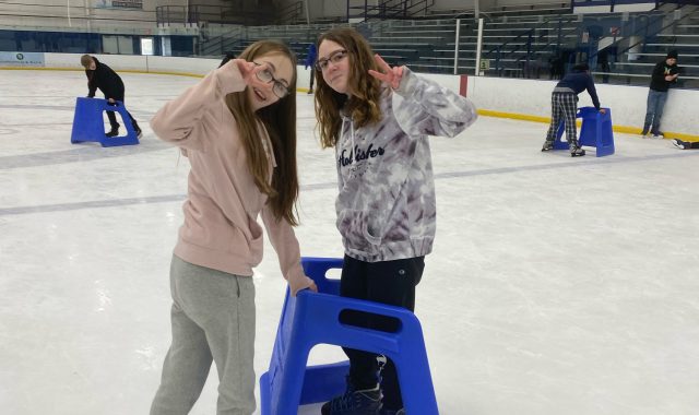 Two students posing on ice rink