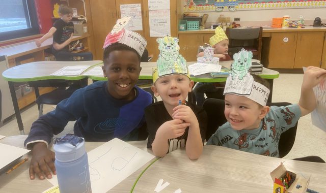 Three students wearing Groundhog hats