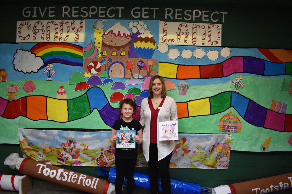 Author Melanie Lopata and Herkimer student by Candy Land display