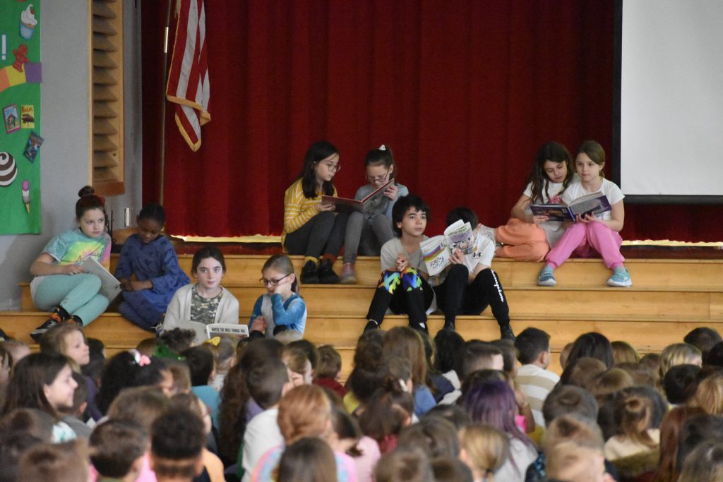 Library Club members reading on stage