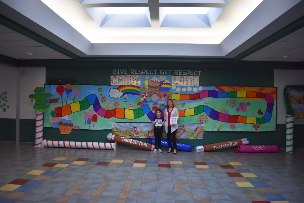 Author Melanie Lopata and Herkimer student by Candy Land display