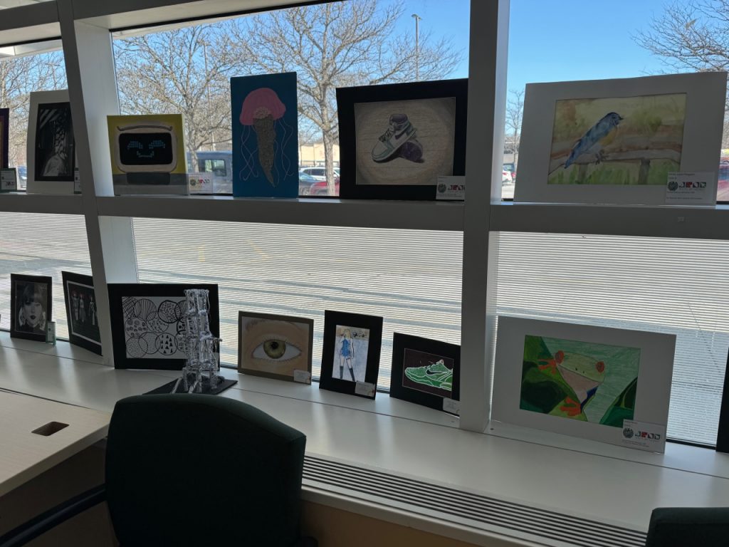 Herkimer student artwork in front of a window