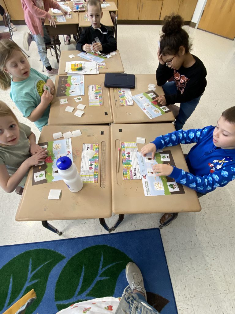 Five second graders doing a strawberry activitiy