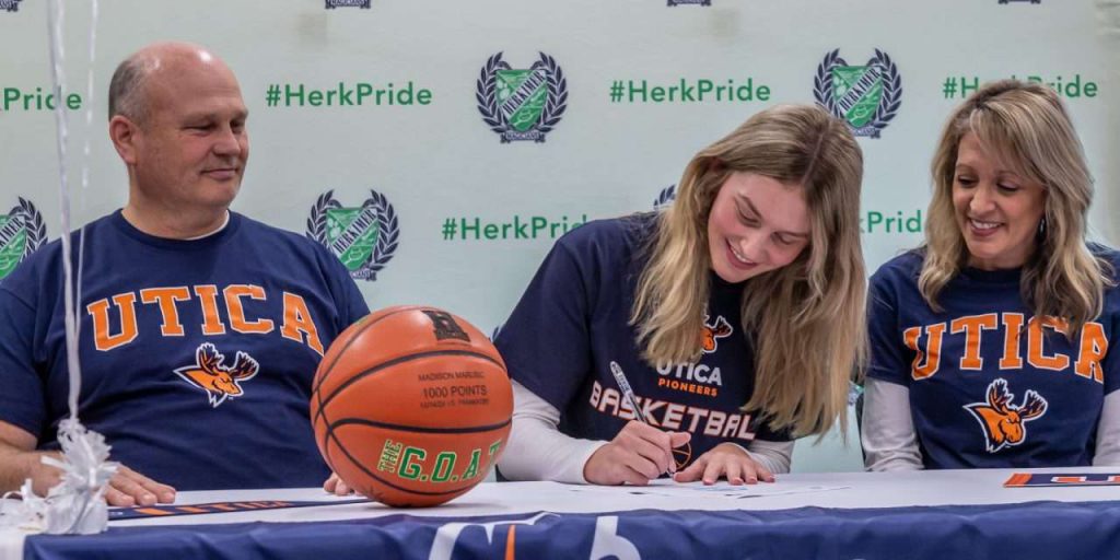 Madison Marusic signing commitment with two people by her