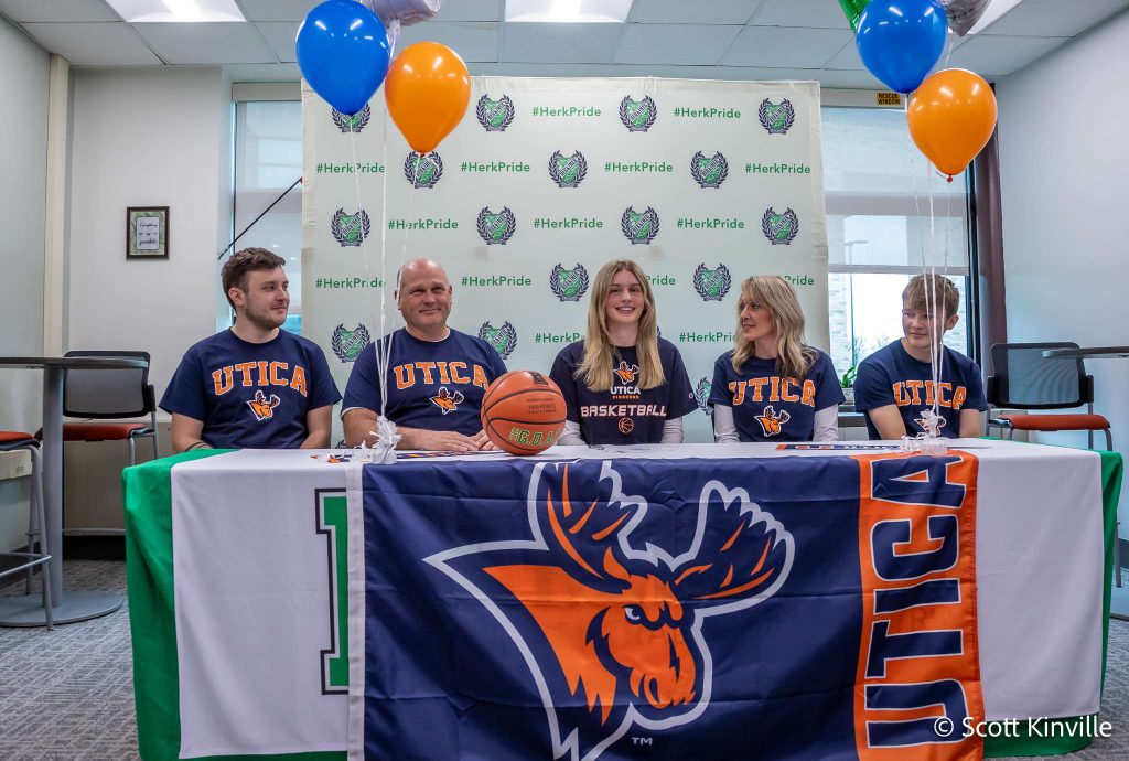 Madison Marusic and four others at her Utica University signing with a Utica University banner on the table