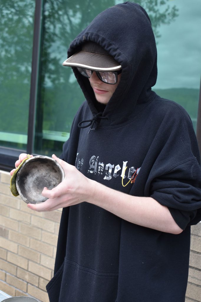 Student waxing a ceramic piece