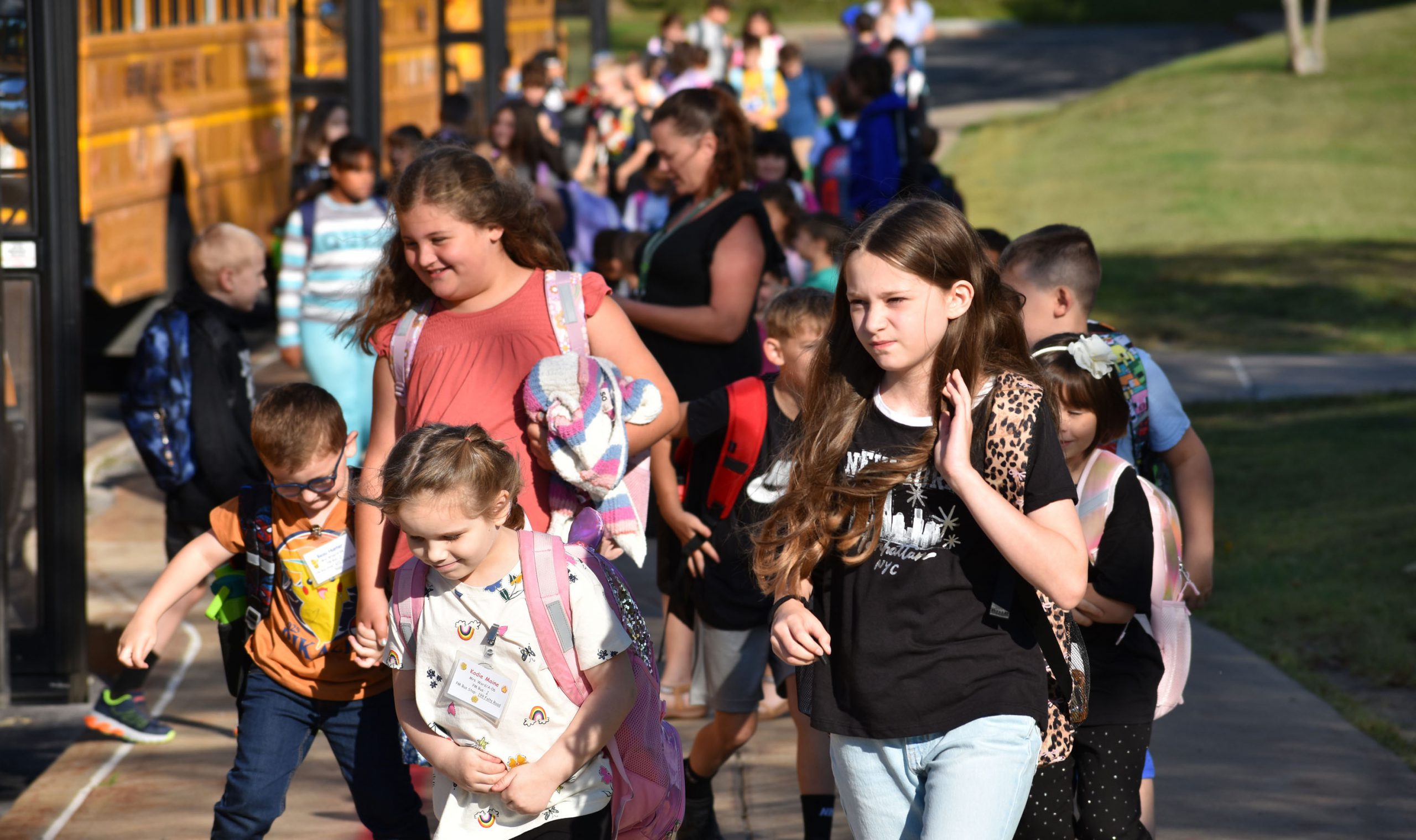 Elementary students walking from the bus to school on first day of school