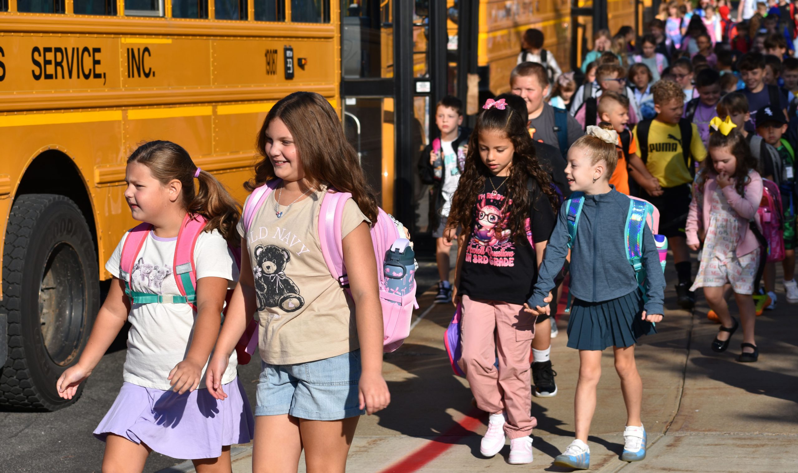 Students walking from the bus to school on first day of school