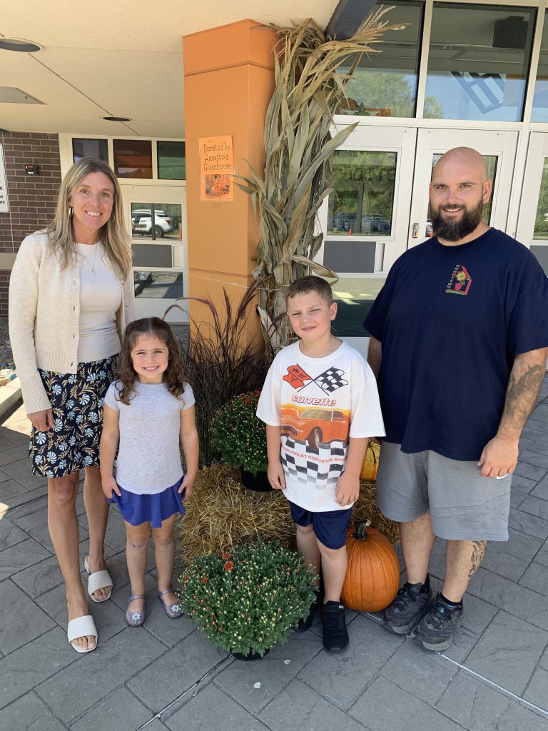Elementary Principal Renee Vogt, two elementary students and Phillip Annutto from Annutto's Greenhouses pose by fall decorations at the Herkimer Elementary School
