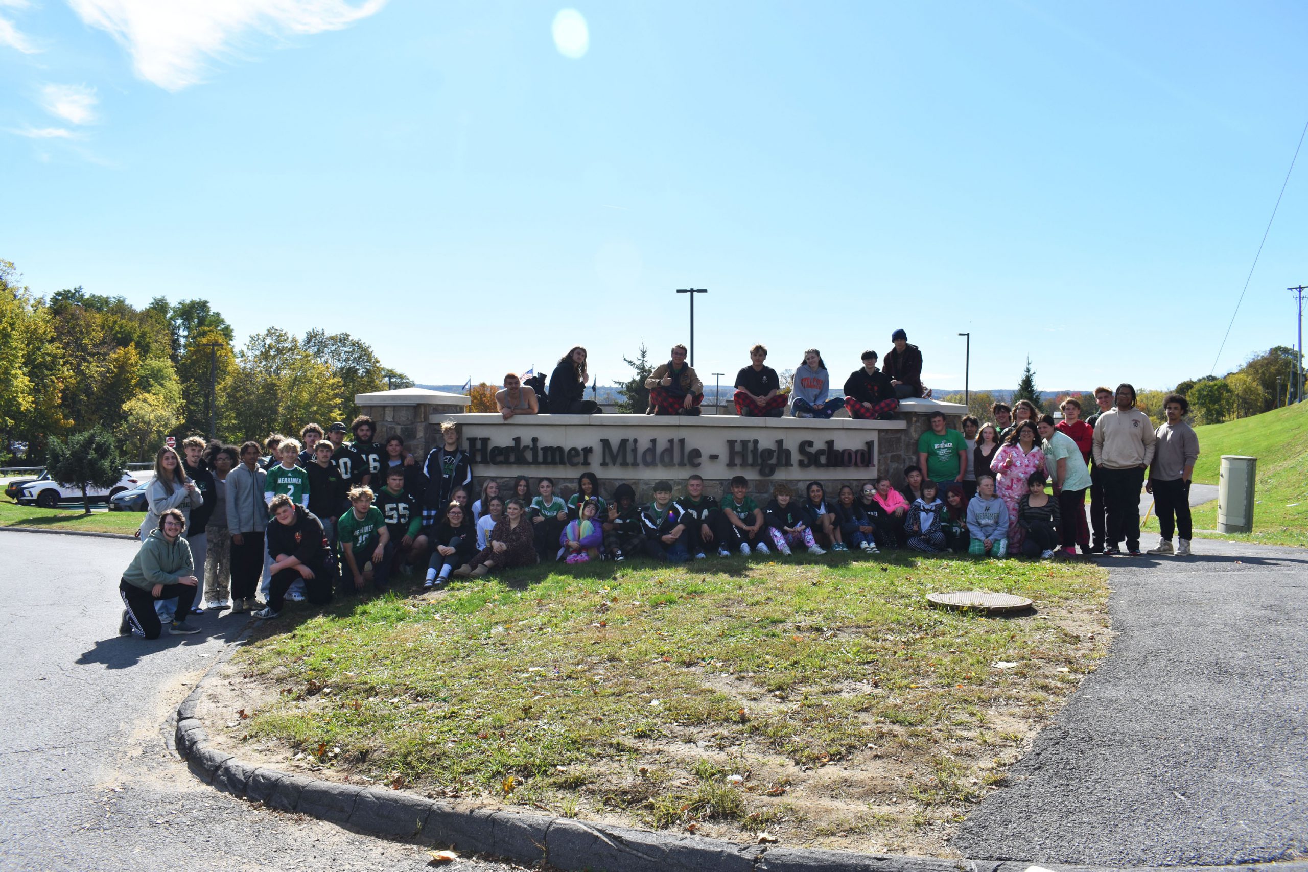 Class of 2026 posing by Middle-High School sign