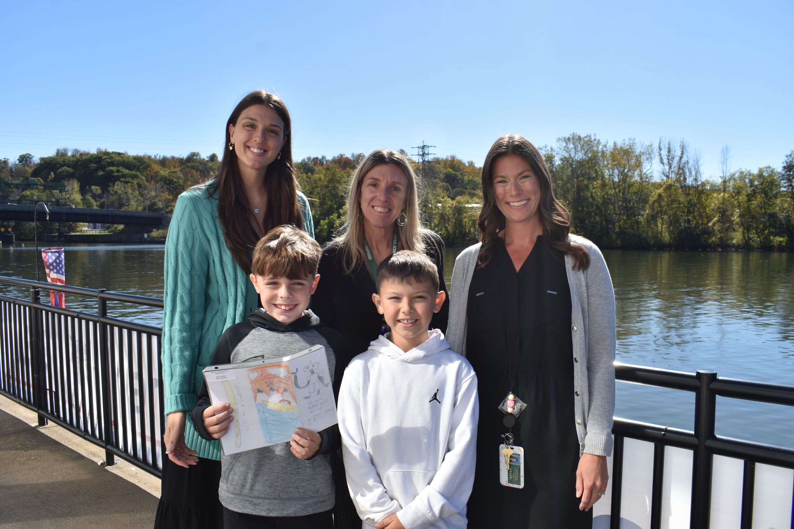 Two students, two teachers and principal by canal for event for student winners
