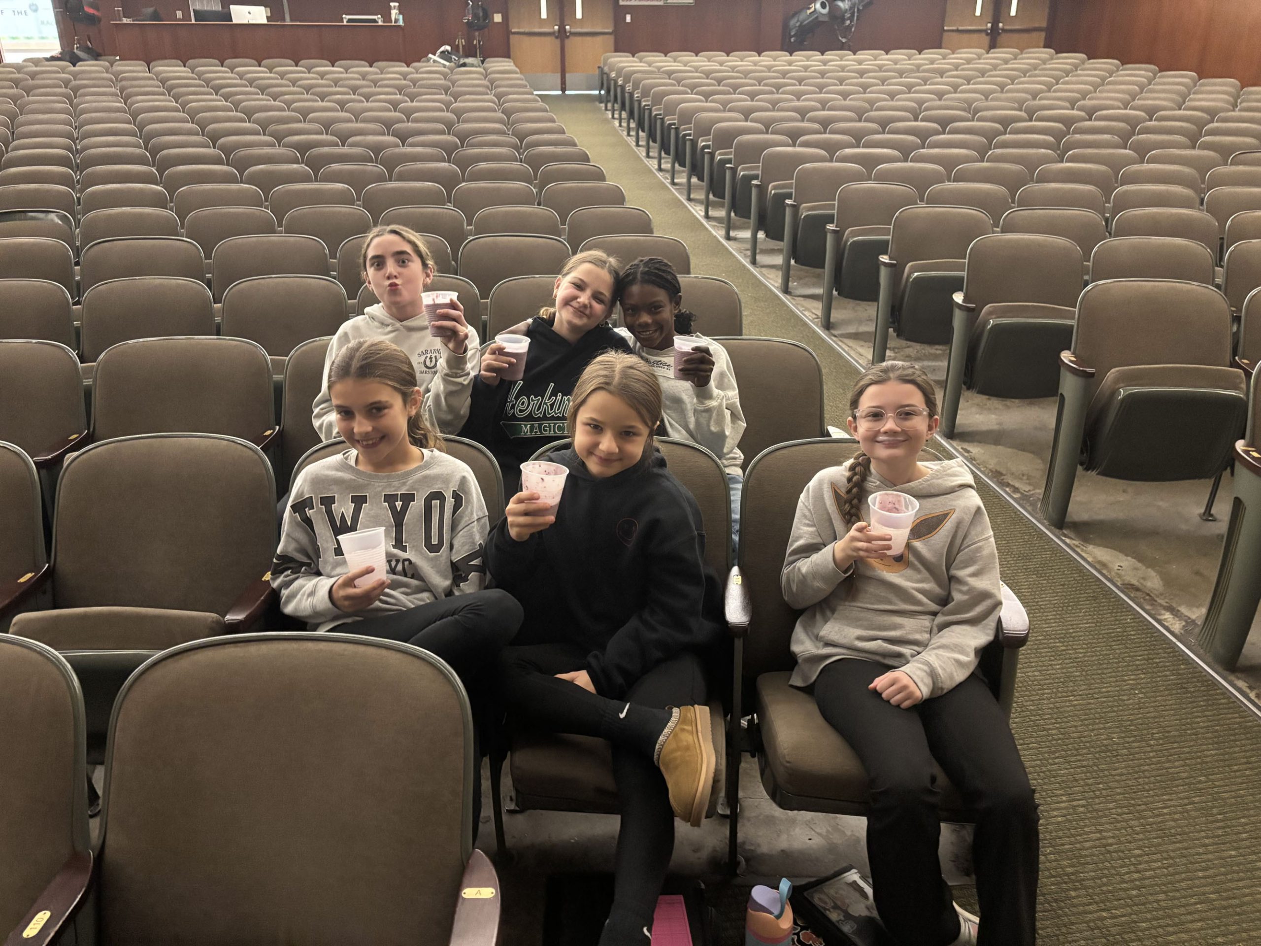 Students with healthy smoothies in auditorium